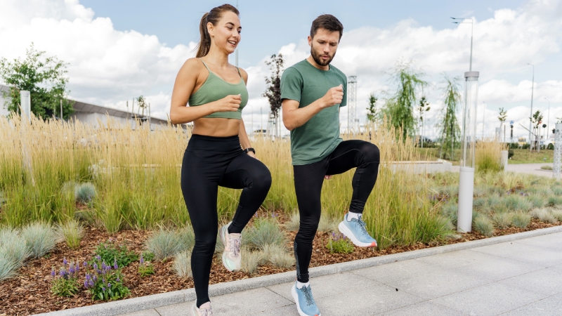 Muškarac i žena rade vežbe podizanja kolena na otvorenom